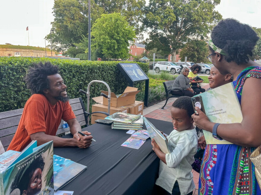Author and illustrator Nikkolas Smith chats with fans during a book signing on Wed., Aug 26 at Fort Monroe in Hampton. Smith is a New York Times best-selling children's author and Hampton University graduate.
