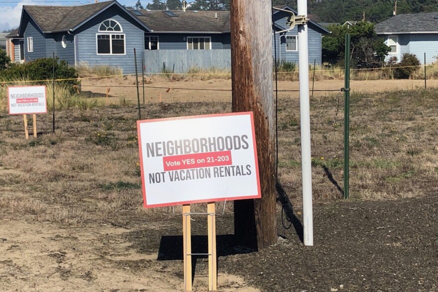 A yard sign stands in front of a vacant lot.