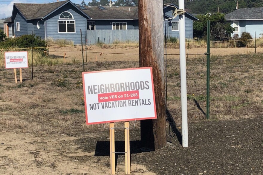 A yard sign stands in front of a vacant lot. 