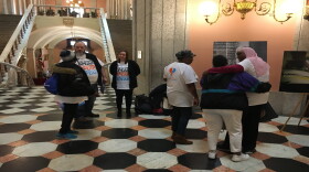 Crime survivors gather in the Statehouse Rotunda after telling their stories to state lawmakers. An exhibit featuring crime survivors' stories is set up in the space.