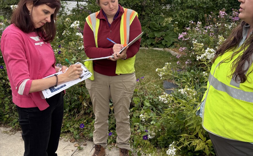 Grasslyn Manor resident and neighborhood advisory committee member Cheryl Wendt (left) confers with Kate Jankowski (center) and Emily Beane. Wendt says many of her neighbors have endured flooding including during the most recent event in August.