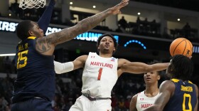 Maryland guard Jahmir Young (1) attempts a layup past West Virginia forward Jimmy Bell Jr. (15) in the first half of a first-round college basketball game in the NCAA Tournament in Birmingham, Ala., Thursday, March 16, 2023. (AP Photo/Rogelio V. Solis)