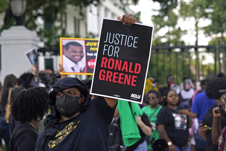 A protester holds a sign that says "Justice for Ronald Greene," as demonstrators stand in front of the Louisiana governor's mansion after a march from the state Capitol in Baton Rouge, La., Thursday, May 27, 2021, protesting the death of Greene, who died in the custody of Louisiana State Police in 2019. 