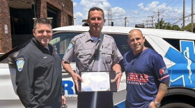 An undated photo shows Scott Montellaro, a paramedic field training officer at American Medical Response New Haven's offices. as he received an award for 30 years of service. Montellaro is in the middle, flanked from right to left by Dave Laspino, an AMR Paramedic Supervisor and Clinical Education Supervisor, and Michael Turcio an AMR Operations Manager, New Haven.