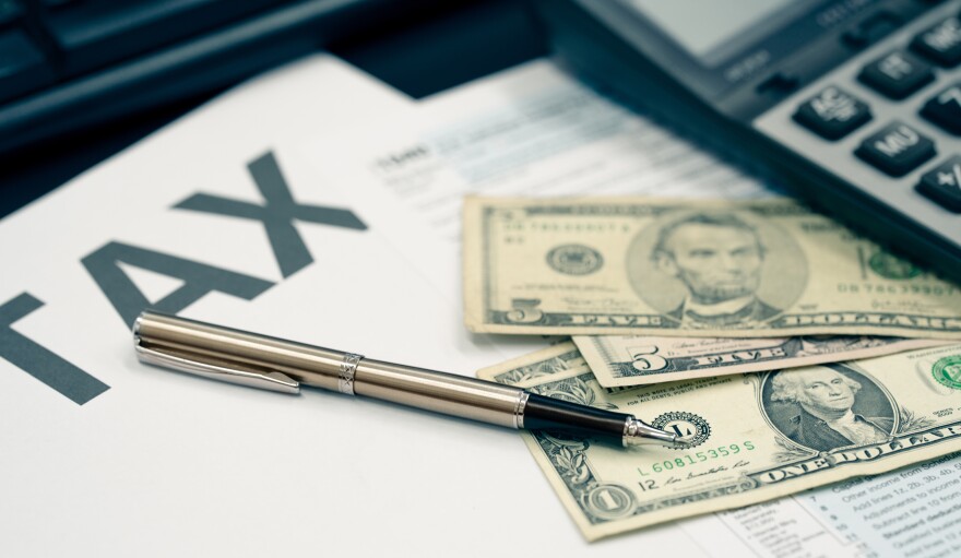 Tax season concept. Tax planning and consulting service business. Pen, calculator, dollar banknote, and income tax return form for filling and calculating tax payments. Money and financial concept.
