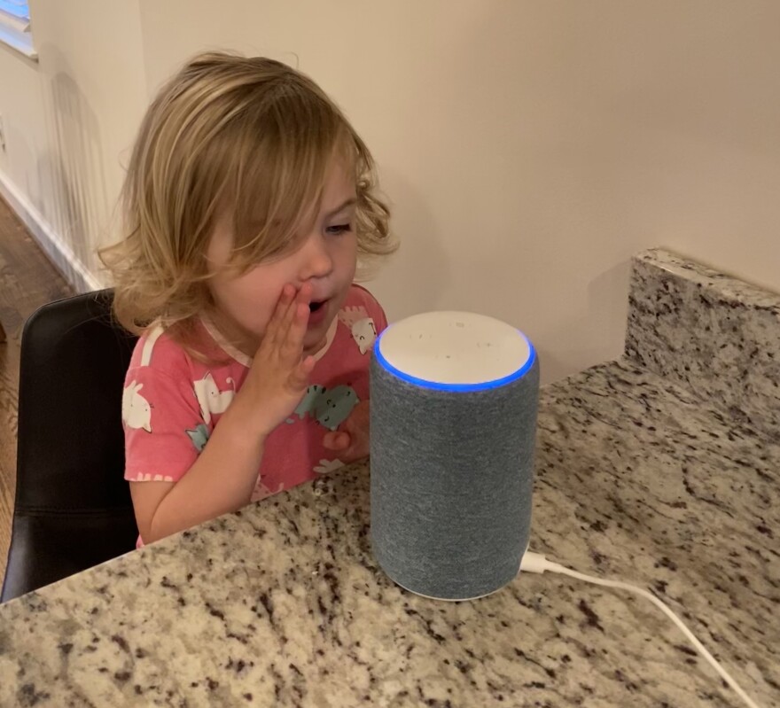 A child whispers secrets to her family's Alexa.