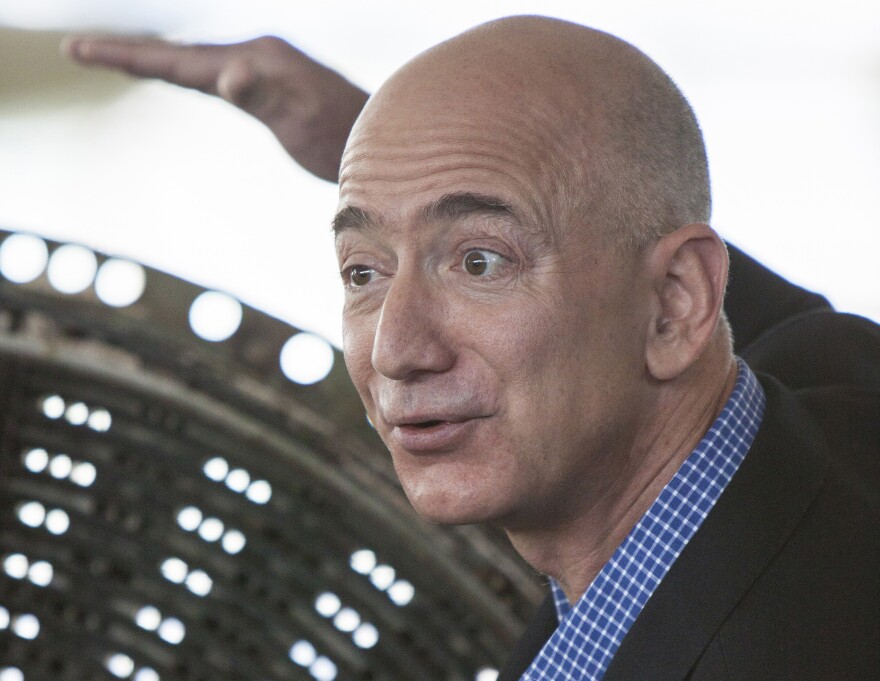 Jeff Bezos speaks at the Apollo rocket engine unveiling at The Museum of Flight, showing the injector plate from an F-1 rocket used on Apollo 12.
