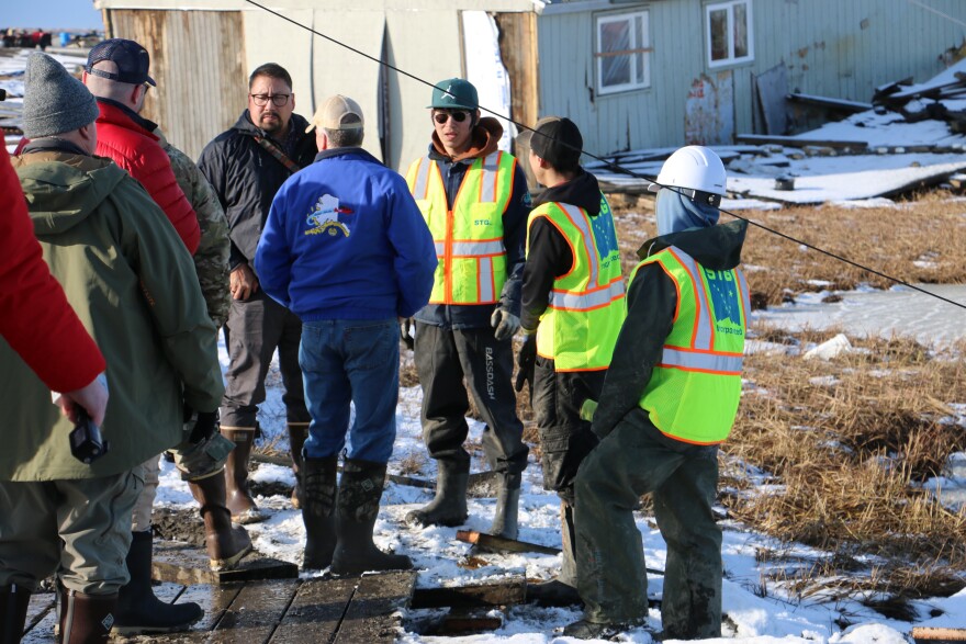 Crews repairing boardwalks in Kipnuk pause to speak with federal officials. Oct. 25, 2025.