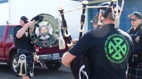 Members of Lane Fire Brigade Pipes and Drums play bass drum and bag pipes.
