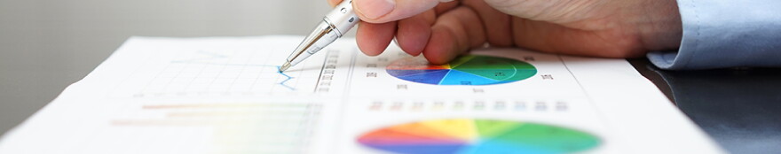 closeup of male hand analyzing business report on black desk