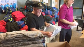 Joel Setzer (left) takes emergency blankets out of their packaging to be put in backpacks to be given to people experiencing homelessness during Jackson County's point-in-time count on Monday. 