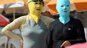 Chinese beachgoers wear face-kinis in Qingdao, northeast China's Shandong province. The face masks allow people to enjoy the water and sand — but not the effects of the sun.