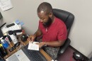Image, brown skinned man putting picture into passport holder.