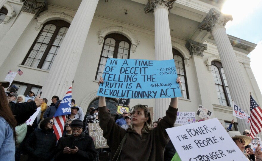 Protestor on the steps of Thalian Hall holding a sign stating "In a time of deceit telling the truth is a revolutionary act" during the No Kings protest.