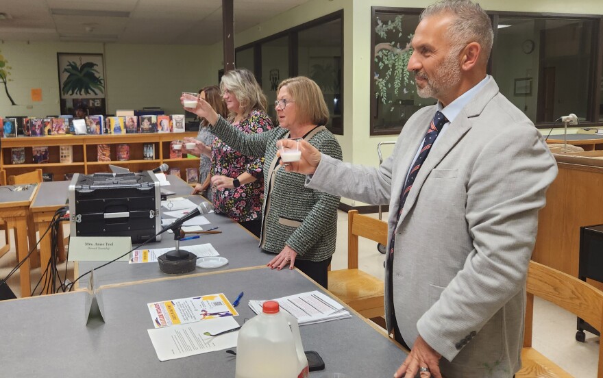 Elk Lake Superintendent Bob Galella and other district leaders toast Arden Tewksbury with cups of whole milk.