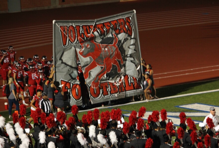 LEE High School's varsity football team breaks through a sign with their new military dog mascot at their first home game of the season Sept. 8, 2018.