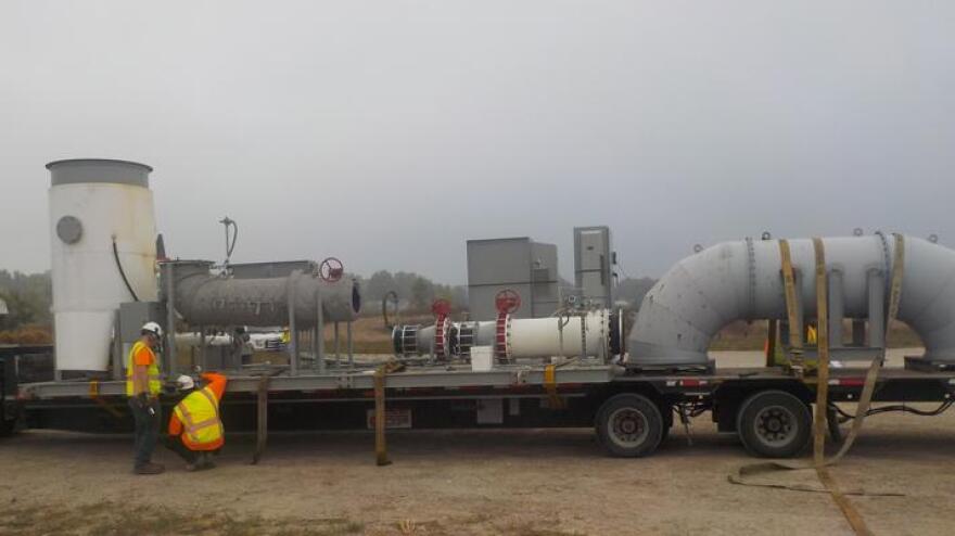 Workers inspect equipment delivered for thermal treatment in Area 1.