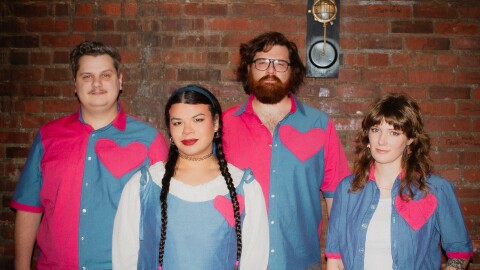a group of four individuals wearing matching outfits posing for a photo