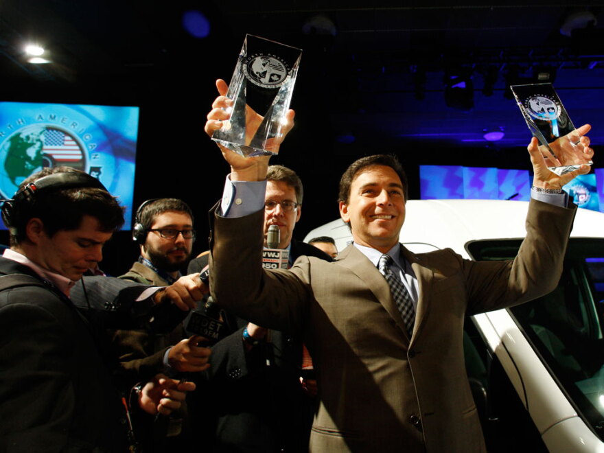 Ford Motor Co. President of the Americas Mark Fields holds up the 2010 North American Truck of the Year award and Car of the Year award Monday at the North American International Auto Show in Detroit.