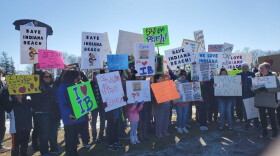 Attendees at Saturday's rally hold signs in support of saving Indiana Beach.