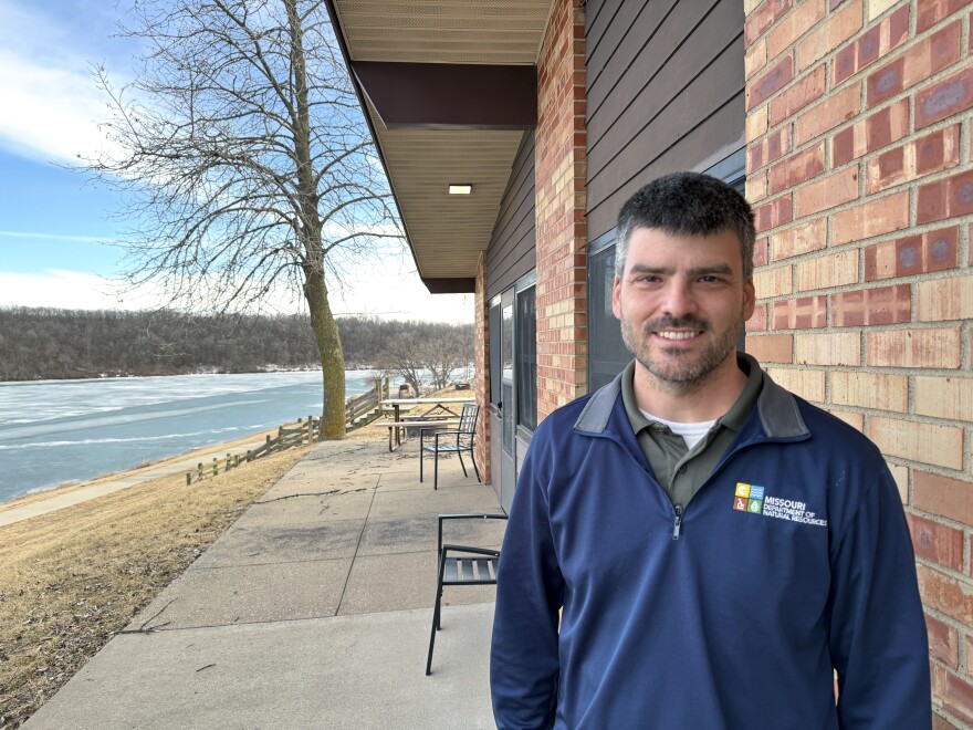 Thousand Hills State Park superintendent Ryan Persinger poses next to one of the park’s cabins. The flat, square light built into the cabin’s awning behind him produces less light pollution than the previous globe-shaped lights. At the same time, it keeps the cabin door well lit and allows visitors to see better by eliminating the glare and bright white color that previously prevented their eyes from adjusting well to nighttime surroundings.