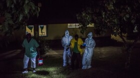 Health workers at an Ebola treatment center, run by Doctors Without Borders, greet a man whose family brought him in by wheelbarrow. They suspected that he had the virus. The center is in Foya, Liberia.