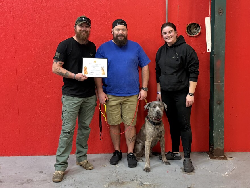 From left to right, co-founder of Devildog Canine Michael Parker, Kris Ellis and his dog Chaos and co-founder of Devildog Canine Laura Slawnikowski.