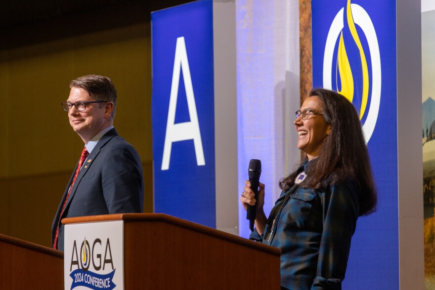 a woman laughing and man standing next to her