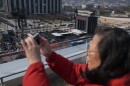 A woman films with her smartphone near a stage for a concert by K-pop group BTS at Gwanghwamun Square in Seoul, South Korea, Friday, March 20, 2026.