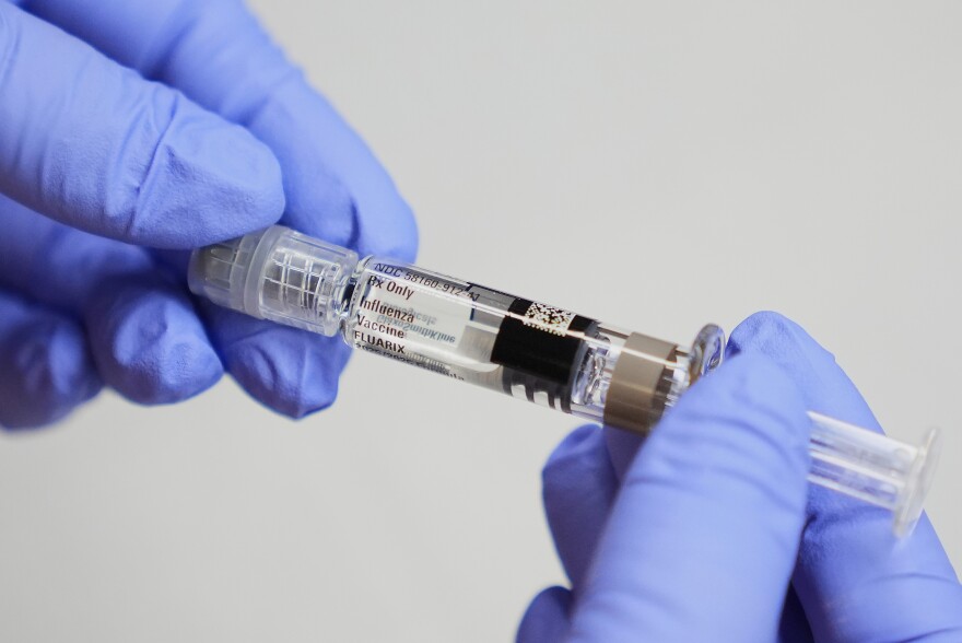 FILE - A certified medical assistant holds a syringe for a flu vaccine at a clinic in Seattle, on Wednesday, Sept. 10, 2025. (AP Photo/Lindsey Wasson, File)