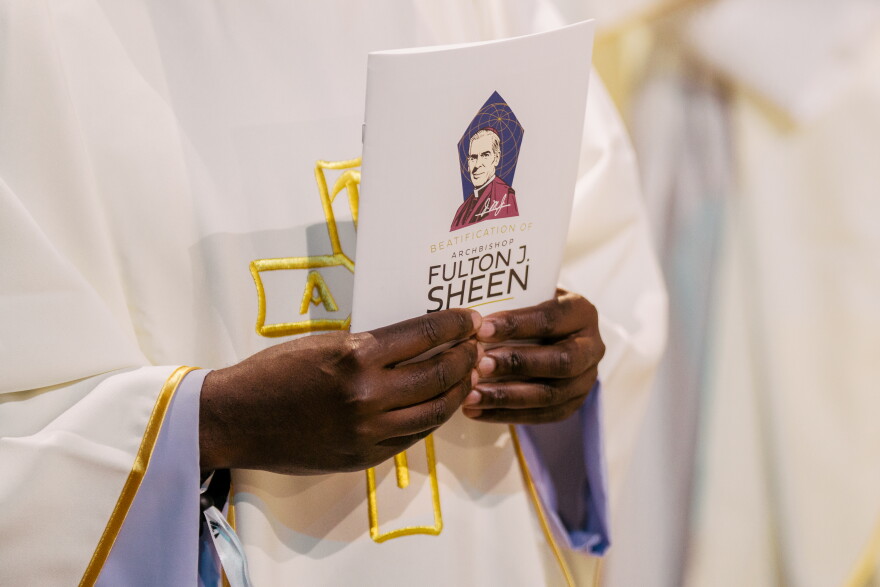 A clergy member holds a program during the beatification Mass for the late Archbishop Fulton J. Sheen on Thursday.