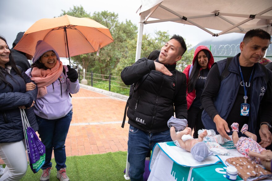 Nelson Alexander Yaguara pretends to wave away the stink of a soiled baby diaper at a pop-up workshop in Bogotá's San Cristóbal neighborhood.