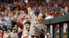 Scooter Gennett, center, is lifted up by Eugenio Suarez as he celebrates in the dugout during the eighth inning of a game against the St. Louis Cardinals on Tuesday, June 6, 2017, in Cincinnati. The Reds won 13-1.