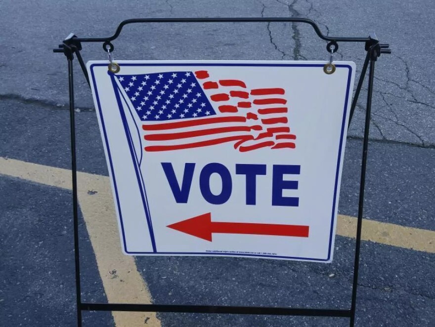 A sign points to a voting precinct