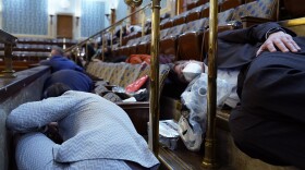 People shelter in the House gallery as protesters try to break into the House Chamber at the U.S. Capitol on Wednesday, Jan. 6, 2021, in Washington. (AP Photo/Andrew Harnik)