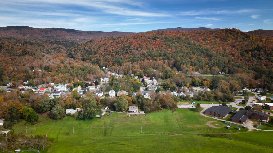 In the background, mountains covered in fall foliage. The town of Rochester sits in front.