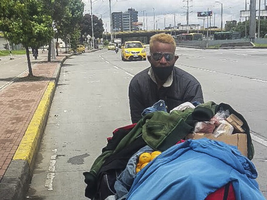 Felix Ruiz, a Venezuelan migrant, pushes a cart along the highway out of Bogotá.