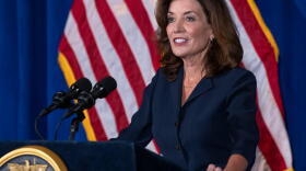 Gov. Kathy Hochul standing at a podium in front of an American flag