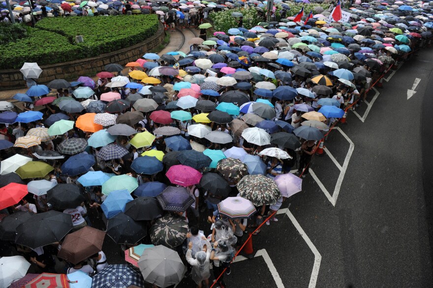 Protesters use umbrellas to deflect the rain Tuesday during a march and rally seeking greater democracy in Hong Kong.