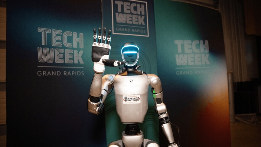 robot in front of logos for Tech Week Grand Rapids 2026