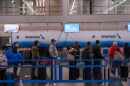 People wait in line to check in to American Airlines flights at Chicago O'Hare International Airport in Chicago, Ill., Sunday, Nov. 9, 2025.