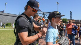 Conor Weber, 12, gets an autograph from Banana Ball Firefighters team member Zachary Bridges on Thursday at Equity Bank Park.