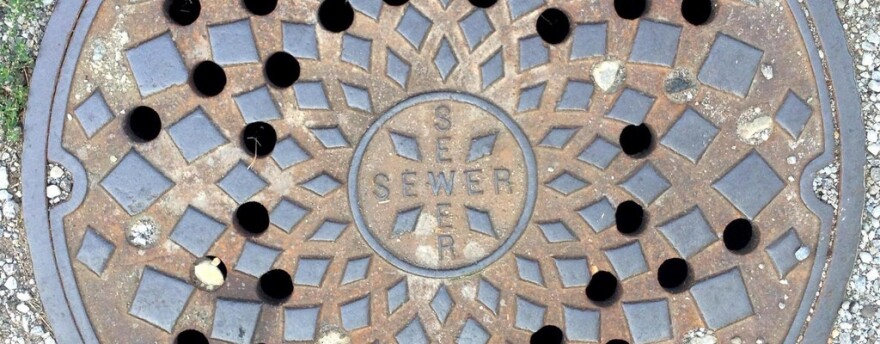 A metal sewer cover is pictured close up. 