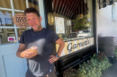 Garnett's manager John Murden holds a cupcake, given to customers on their 17th birthday, celebrated earlier this month. 