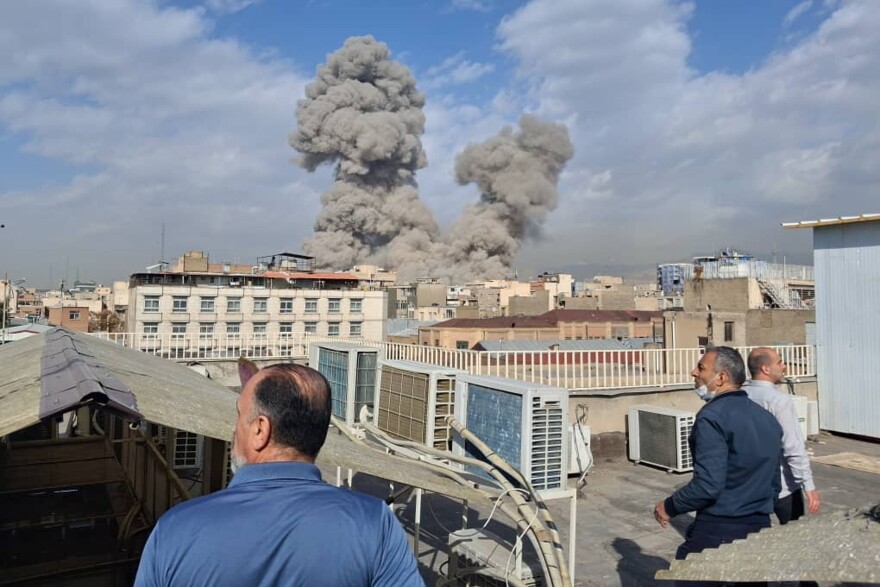 People watch as smoke rises on the skyline after an explosion in Tehran, Iran, on Saturday, Feb. 28, 2026.