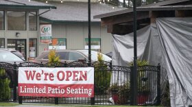 A sign at the El Sarape restaurant advertises outdoor seating, Jan. 5, 2021, in Olympia, Wash., as indoor dining was prohibited statewide due the the governor's coronavirus safety measures. CREDIT: Ted S. Warren/AP