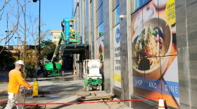 Workers clean up the outside of the new Kroger store, Tuesday morning.