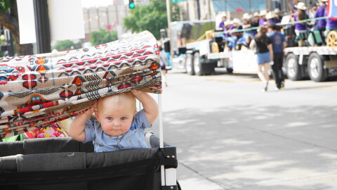 A baby watches the parade