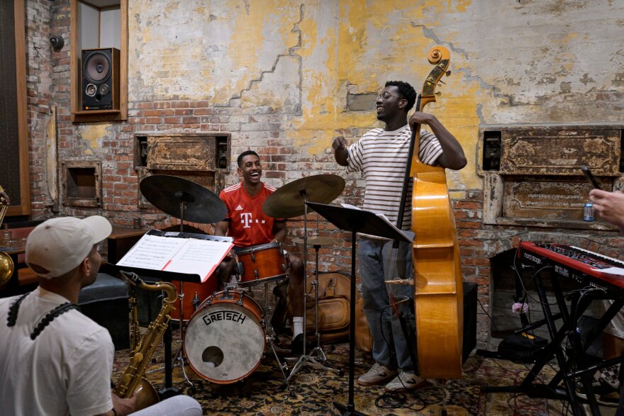 During their second practice at the Courtland Club in Providence, Rhode Island, Drummer Marcus Grant jokes around with Bassist, Kweku Aggrey about who was late and who was off beat, resulting in both of them making fun of each other.