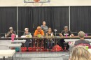 a group of people sit at a table answering questions